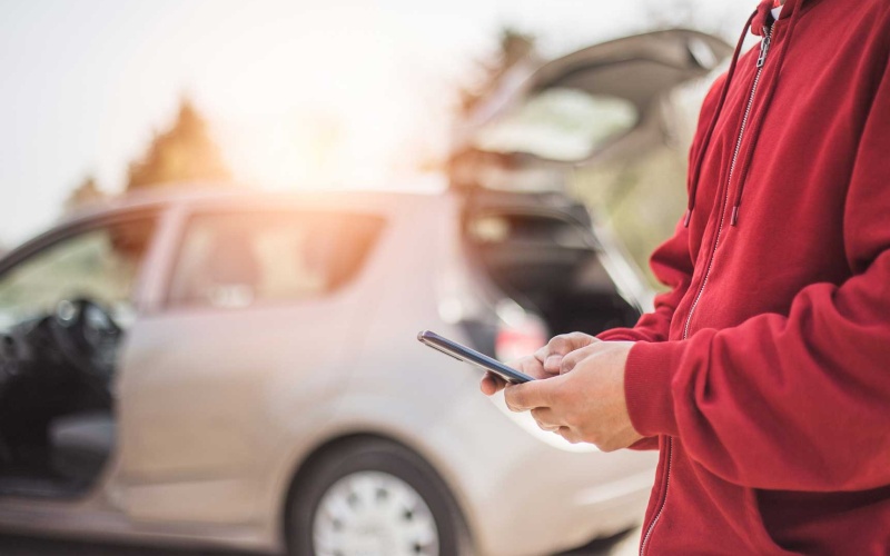 stock photo of person texting outside of car accident