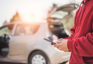 stock photo of person texting outside of car accident